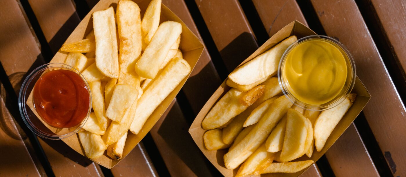Twee bakjes verse friet met sausjes ernaast — representatief beeld.